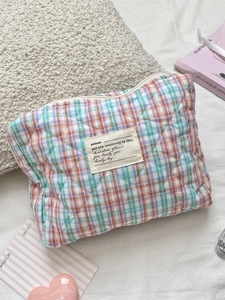 Pastel checkered quilted toiletry bag with mint green and orange patterns for storage