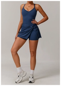 Detail view of navy blue tennis skort featuring side twist knot and pleated crossover hem