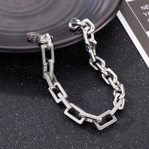 Detail of silver geometric chunky chain bracelet with industrial fishhook clasp on black