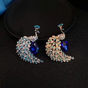 Detail view of colorful peacock brooches with sparkling crystals and blue gemstones