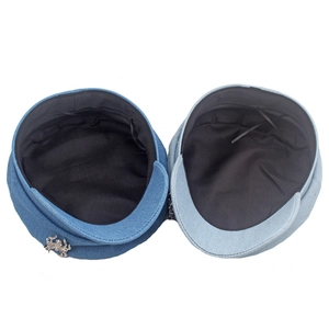 Détail de casquettes marin en denim bleu marine et clair avec badge araignée et cordon réglable