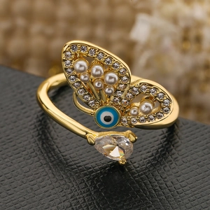 Detail of butterfly ring with blue evil eye, pearls and pear-cut zircon on black leather