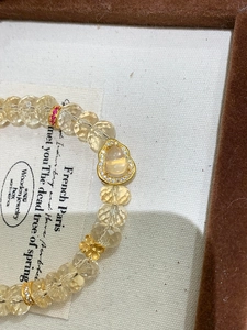 Détail du bracelet en perles de cristal jaune avec pendentif Bouddha et zircons