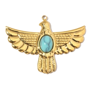 Macro shot of golden eagle pendant with marble turquoise stone and detailed metalwork