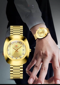 Detail of gold business watch featuring diamond-cut crystal glass and date window