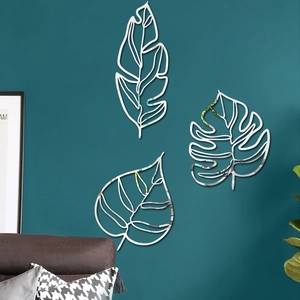 Stickers muraux feuilles miroir argenté modernes sur un mur bleu canard élégant