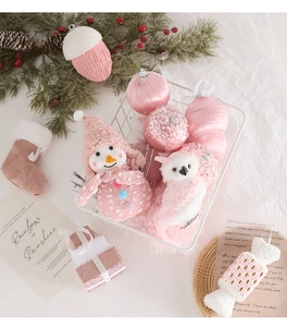 Pink Christmas ornaments set with plush snowman and decorative baubles in a white basket