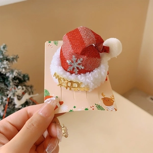 Macro detail of red glitter Christmas hat hair clip with Merry text and snowflake accents