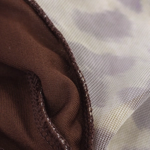 Dettaglio del tessuto a maglia marrone unito a materiale mesh stampato per una texture