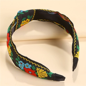Detailed close-up of ethnic style knotted headband with colorful floral embroidery