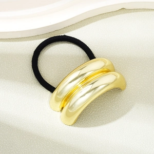Detailed view of an elegant gold metal hair tie with durable black elastic hair band