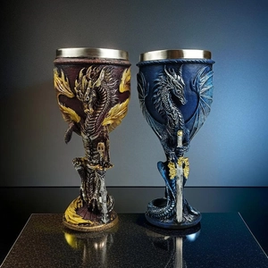 Detail view of dragon and sword themed wine goblets with intricate gothic metal carving