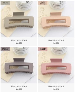 Detailed view of four matte large square hair claws in khaki, orange, and pink colors