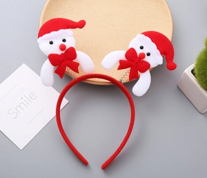 Detail of Christmas headband featuring 3D plush snowmen with red festive hats and bows