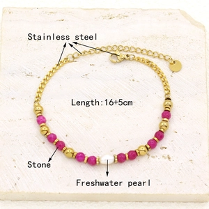 Detail view of gold-plated stainless steel bracelet with magenta stones and pearl
