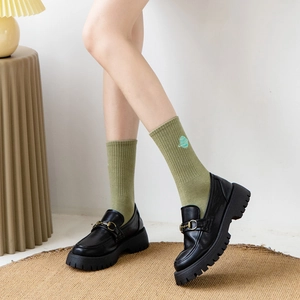 Green mid-tube cotton socks with planet embroidery paired with black horsebit loafers