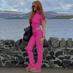 Dettaglio del set con crop top attillato rosa ciliegia e pantaloni svasati a vita alta