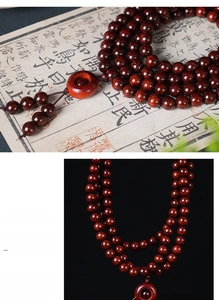 Detailed close-up of dark red sandalwood beads with a retro Ping'an Kou pendant charm