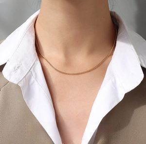 Detailed close-up of a 1.8mm gold-plated angular link chain necklace worn on a neck