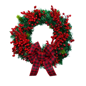 Christmas wreath with red black plaid bow and red berries on green pine needles