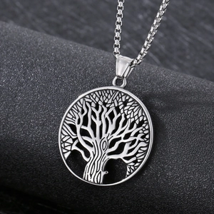 Close-up of silver stainless steel Tree of Life pendant with box chain on black surface