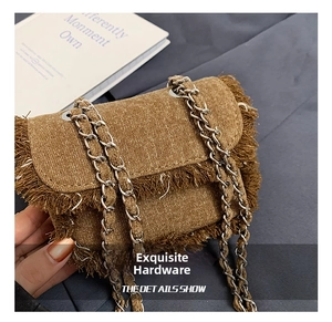 Detailed close-up of brown denim mini bag with frayed edges and silver chain strap