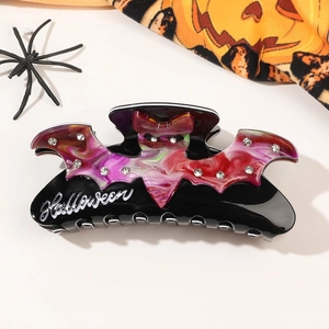 Detail of Halloween claw clip with bat wings, rhinestones and Halloween text on black acrylic