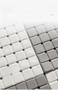 Detail of TPE bathroom mats showing interlocking drainage tiles and soft texture