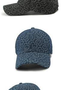 Détail d'une casquette en denim avec motif de cœurs en jacquard et texture tissée