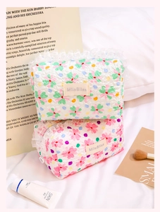 Close-up of quilted floral cosmetic bags with lace trim and zipper in a cozy setting