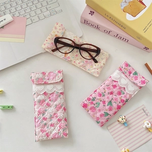 Detailed view of quilted floral glasses pouches with lace trim and heart button closures