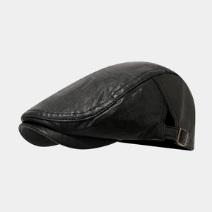 Close-up of black leather flat cap showing retro wrinkled texture and side metal buckle