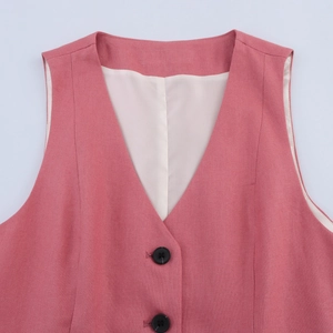 Detail of pink V-neck vest featuring cotton linen texture and contrast black buttons