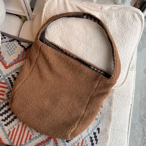 Close-up of brown faux shearling tote bag with stylish black and white checkered lining