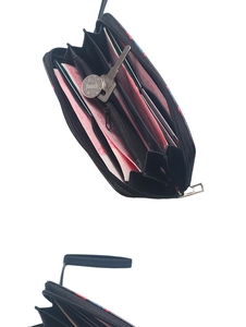 Detail view of the spacious inner compartments with cards, cash, and keys in a black wallet