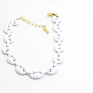 Detail of white coffee bean link necklace featuring gold adjustable chain and lobster clasp