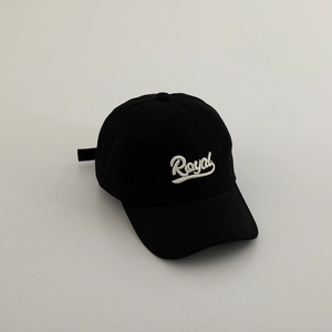 Close-up of white Royal embroidery on a black cotton twill baseball cap for kids