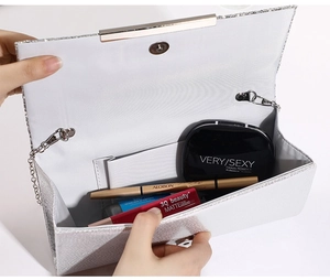 Detail view of the silver glitter evening bag interior showing its capacity and inner pocket