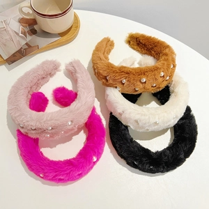 Plush faux fur headbands with pearl accents in five assorted colors on a white table