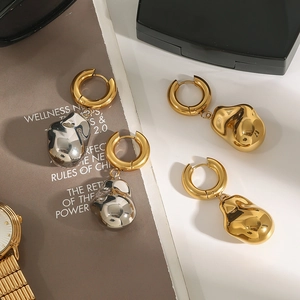 Boucles d'oreilles luxe goutte de lave irrégulière en or et argent sur fond chic
