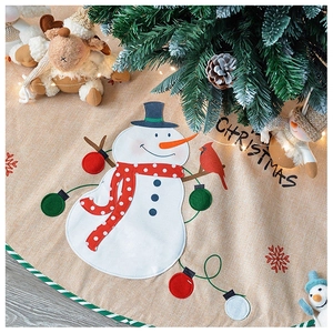 Detail of linen Christmas tree skirt with plush snowman applique and rustic pine cones
