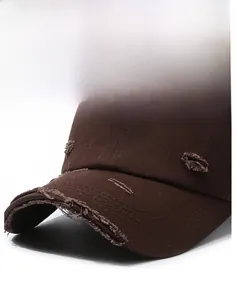 Detail of dark brown distressed baseball cap showing frayed brim and vintage cotton texture