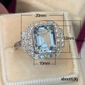 Art Deco aquamarine zircon ring with emerald cut stone in a beige velvet jewelry box