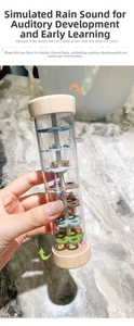 Detail of rainmaker percussion toy showing colorful beads and inner gears in plastic tube
