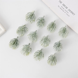 Top view of 12 artificial frosted pine needles for Christmas DIY decor on white background