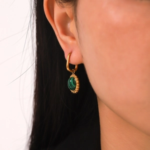 Close-up of French vintage gold twisted earrings with oval malachite pendant worn on ear