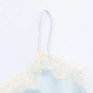 Detail of light blue satin camisole featuring delicate eyelash lace trim at the neckline