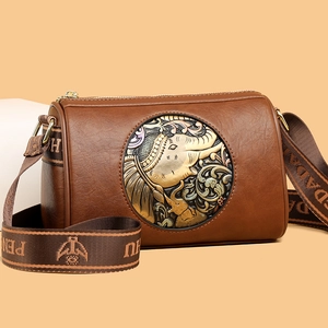 Brown cylinder shoulder bag featuring vintage elephant embossing and patterned strap