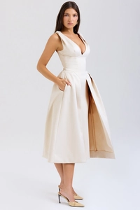 Détail du décolleté en V profond et du tissu en satin de la robe de soirée crème