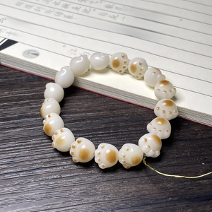 Close-up of cat paw shaped beads on a sweet white and brown Bodhi root bracelet